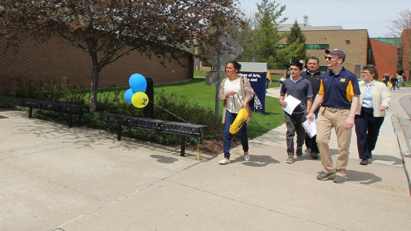 Group of prospective students and families walking on campus.