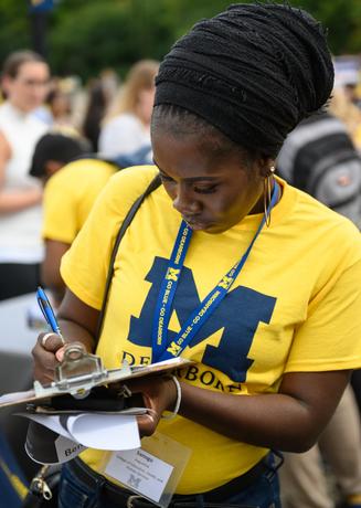 A student filling out a form during graduate orientation