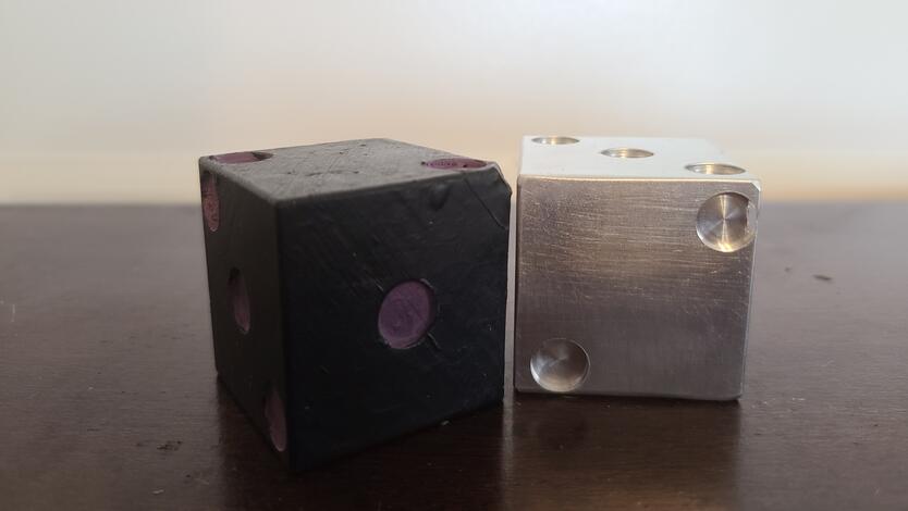 3D-printed and milled six-sided dice. The toy demonstrates the STEM concepts of probability and manufacturing designs.
