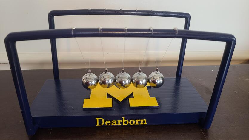 Newton’s cradle. The toy demonstrates the STEM concept of the conservation of energy by transforming stored potential energy into kinetic energy.
