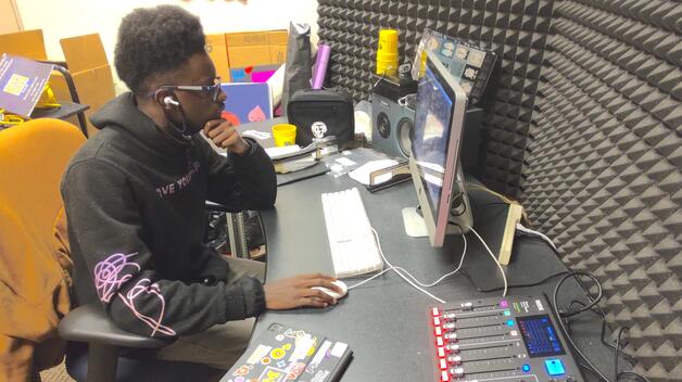 Photo of a WUMD student DJ in the Wolverine Media Network office.